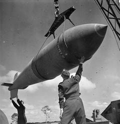 © IWM (CH 15363) A 12,000-lb MC deep-penetration bomb (Bomber Command executive codeword 'Tallboy') is hoisted from the bomb dump to its carrier at Woodhall Spa, Lincolnshire, to be loaded into an Avro Lancaster of No. 617 Squadron RAF for a raid on the V-weapon site at Wizernes, France, 22 June 1944. 617 Squadron were unable to bomb the target on this occasion because of low cloud cover, but were to succeed two days later.